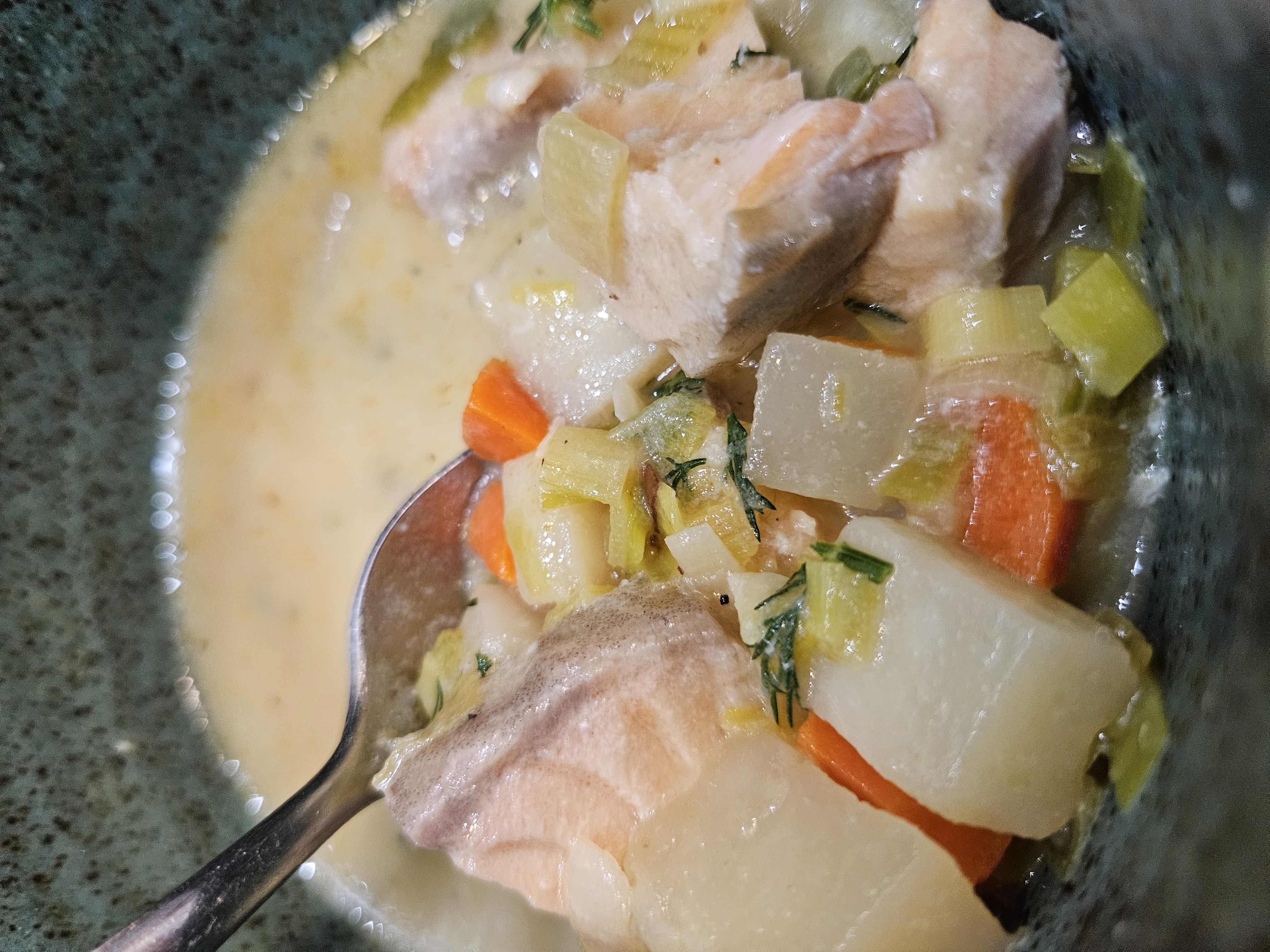 Chunks of Salmon float in a cream sauce with potatoes, carrots, leeks, and dill.