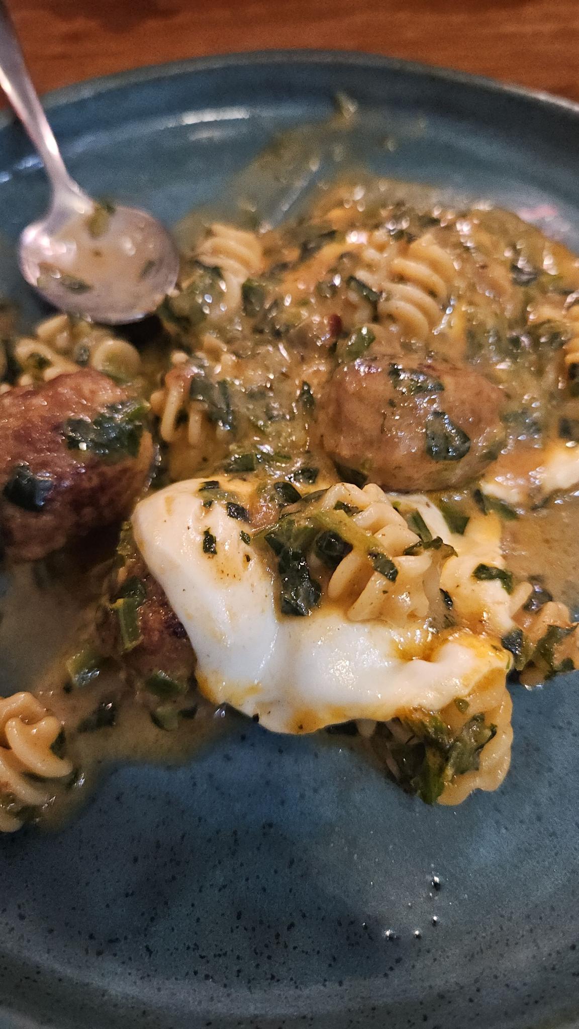 Meatballs on a green plate with spinach cream